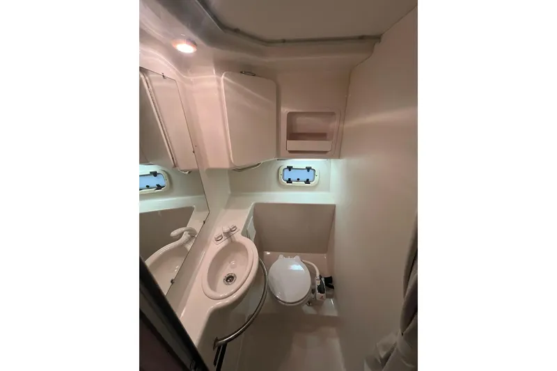 Slide: The Image of Compact bathroom in 1997 Maxum 2800 SCR boat with sink, toilet, and storage. - 18
