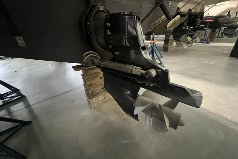 Slide: The Image of 1997 Maxum 2800 SCR boat propeller and stern drive on wooden blocks in storage. - 19