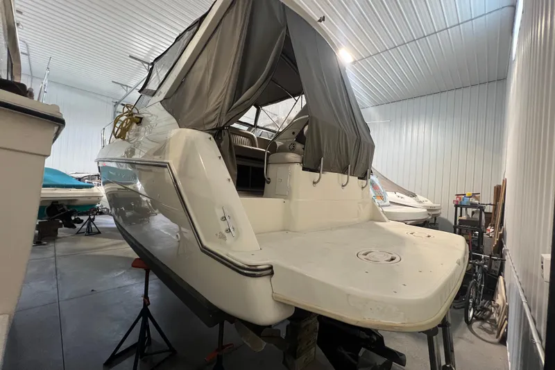 Slide: The Image of 1997 Maxum 2800 SCR boat in indoor storage, rear view with covered cockpit. - 2