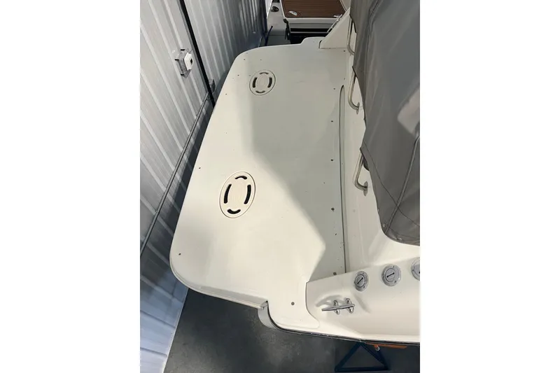 Slide: The Image of 1997 Maxum 2800 SCR boat stern view in storage, featuring swim platform and cover. - 3