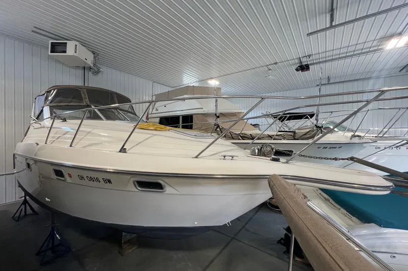Slide: The Image of 1997 Maxum 2800 SCR boat in indoor storage, surrounded by other vessels. - 6