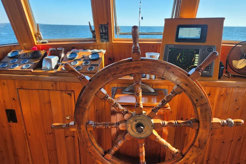Slide: The Image of 1958 Stephens Brothers Naval Yard Patrol Craft helm with wooden wheel and navigation instruments. - 12