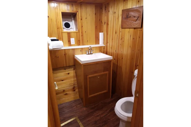 Slide: The Image of Wood-paneled bathroom in 1958 Stephens Brothers Naval Yard Patrol Craft, featuring sink and porthole window. - 13