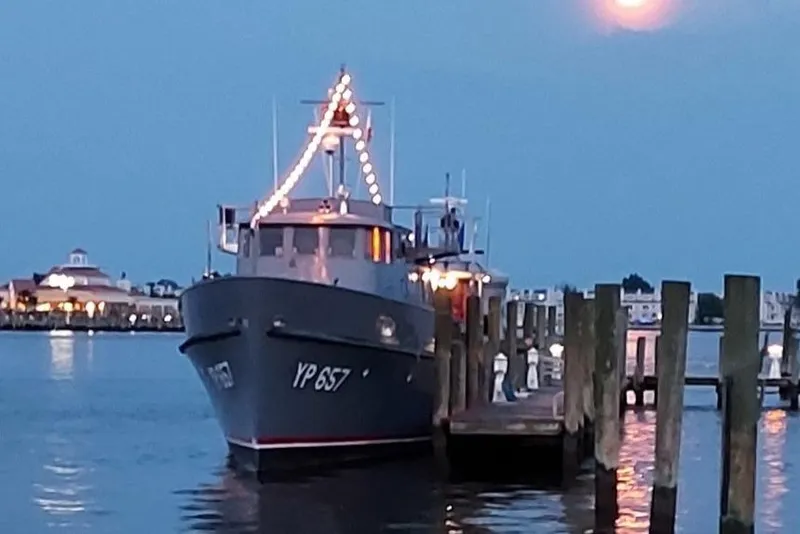 Slide: The Image of 1958 Stephens Brothers Naval Yard Patrol Craft YP 657 docked at sunset with lights. - 5