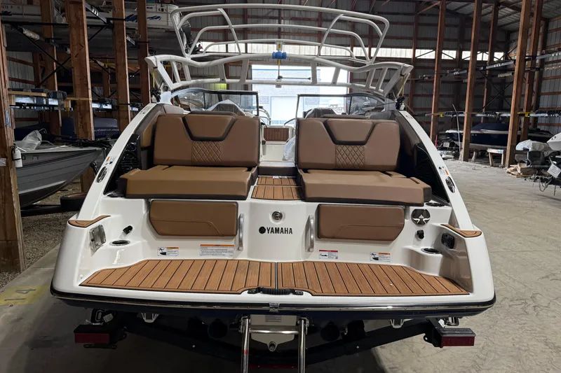 Slide: The Image of 2025 Yamaha Boats 252SD in storage, showcasing rear seating and deck design. - 2