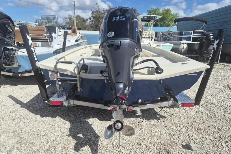 Slide: The Image of 2026 Xpress H20 boat with powerful outboard motor, parked on gravel lot. - 2