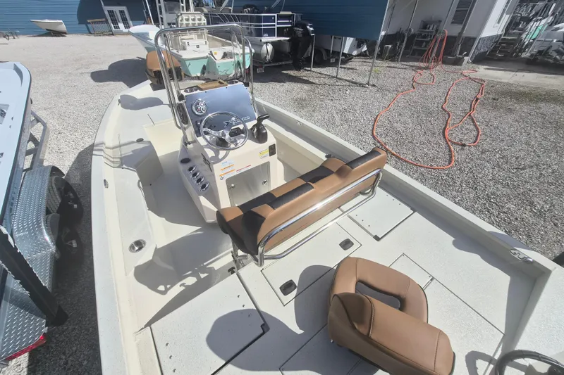 Slide: The Image of 2026 Xpress H20 boat interior with steering console and seating, parked outdoors. - 3