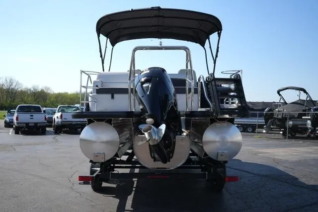 Slide: The Image of 2026 Harris Cruiser 210 pontoon boat on trailer, rear view, in a parking lot. - 12