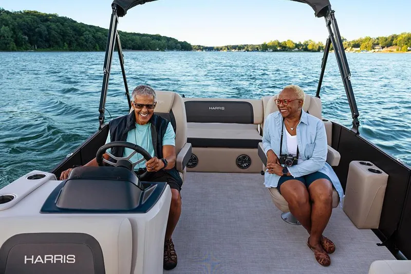 Slide: The Image of Manufacturer Provided Image: Couple enjoying a ride on a 2025 Harris Cruiser 210 boat on a sunny lake. - 5