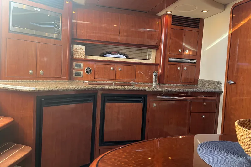 Slide: The Image of Luxurious 2005 Sea Ray 390 Express Cruiser interior with elegant wood cabinetry and modern amenities. - 11