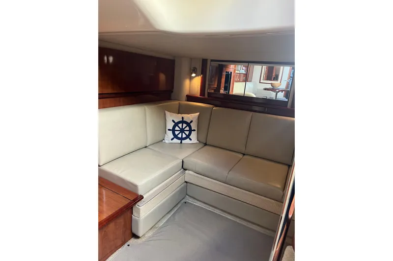Slide: The Image of Interior of 2005 Sea Ray 390 Express Cruiser with beige seating and nautical-themed pillow. - 16