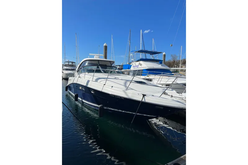 Slide: The Image of 2005 Sea Ray 390 Express Cruiser docked at marina under clear blue sky. - 2