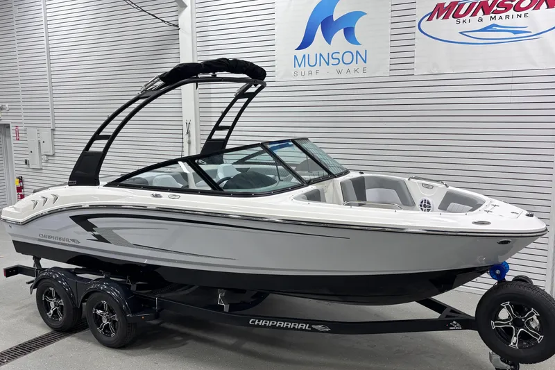 Slide: The Image of 2026 Chaparral 21 SSi boat on trailer in showroom, Munson Surf Wake banners. - 9