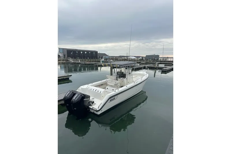 The Image of 2001 Boston Whaler 26 Outrage boat docked in a marina under cloudy skies. - 1