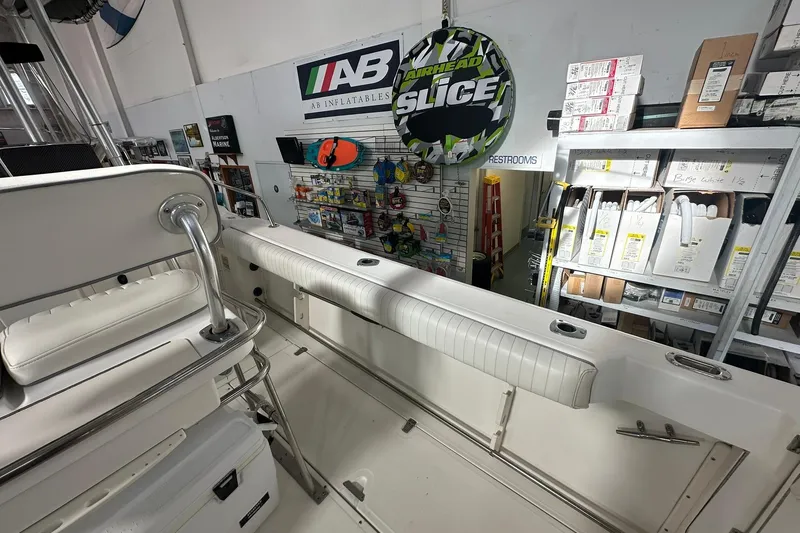 Slide: The Image of 2001 Boston Whaler 26 Outrage interior with seating and storage, displayed in a marine shop. - 13