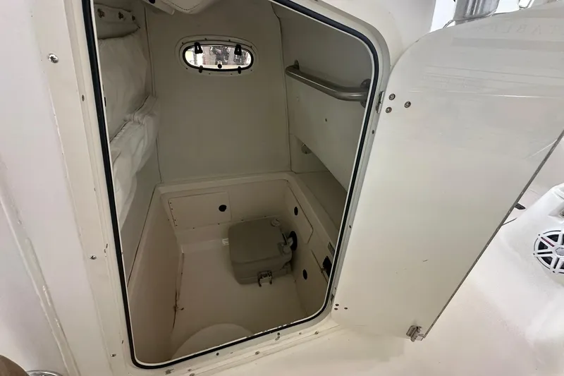 Slide: The Image of Interior cabin of a 2001 Boston Whaler 26 Outrage boat, featuring a compact restroom. - 15