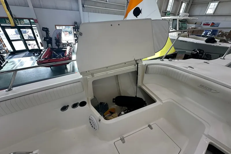 Slide: The Image of 2001 Boston Whaler 26 Outrage boat interior with open storage compartment in showroom. - 16
