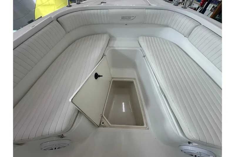 Slide: The Image of 2001 Boston Whaler 26 Outrage boat interior with open storage compartment and cushioned seating. - 18