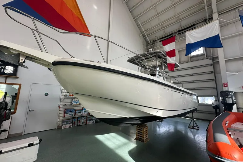 Slide: The Image of 2001 Boston Whaler 26 Outrage boat displayed indoors with colorful flags above. - 4