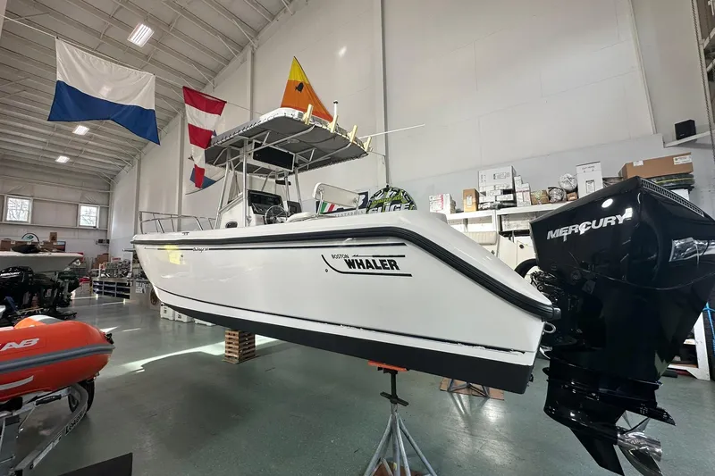 Slide: The Image of 2001 Boston Whaler 26 Outrage boat in showroom with Mercury engine. - 5