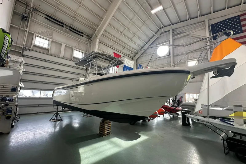 Slide: The Image of 2001 Boston Whaler 26 Outrage boat displayed indoors, elevated on stands. - 6