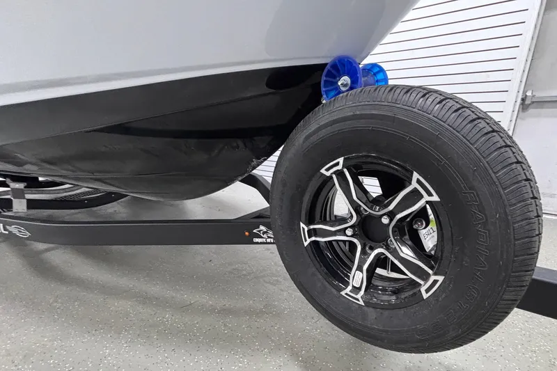 Slide: The Image of 2026 Chaparral 21 SSi boat trailer with black tire and sleek design. - 3