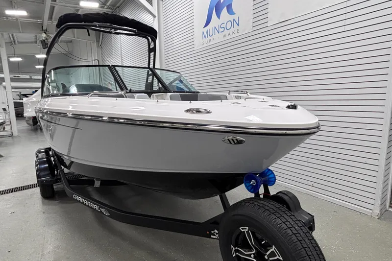 Slide: The Image of 2026 Chaparral 21 SSi boat on trailer in showroom, Munson Surf Wake sign visible. - 4