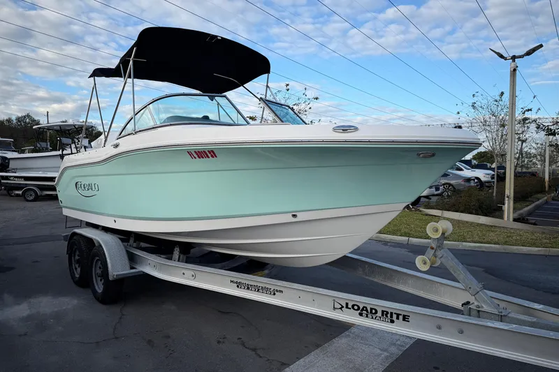 The Image of 2020 Robalo R207 Dual Console boat on trailer, parked outdoors under blue sky. - 0