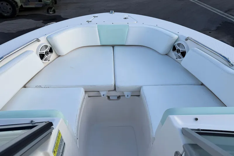 Slide: The Image of 2020 Robalo R207 Dual Console boat interior with white cushioned seating and speakers. - 10