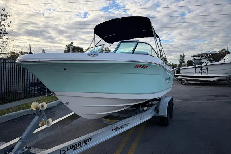 Slide: The Image of 2020 Robalo R207 Dual Console boat on trailer under cloudy sky. - 2