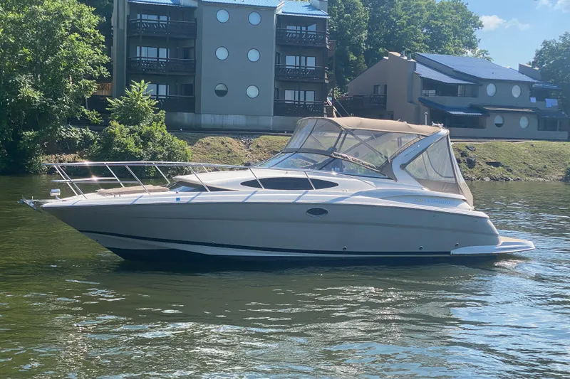 Slide: The Image of 2008 Regal 3360 Window Express boat on a calm river near modern buildings. - 6