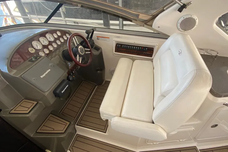 Slide: The Image of 2008 Regal 3360 Window Express boat cockpit with steering wheel and white seating. - 13