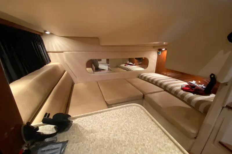 Slide: The Image of 2008 Regal 3360 Window Express cabin interior with beige seating and striped cushions. - 30