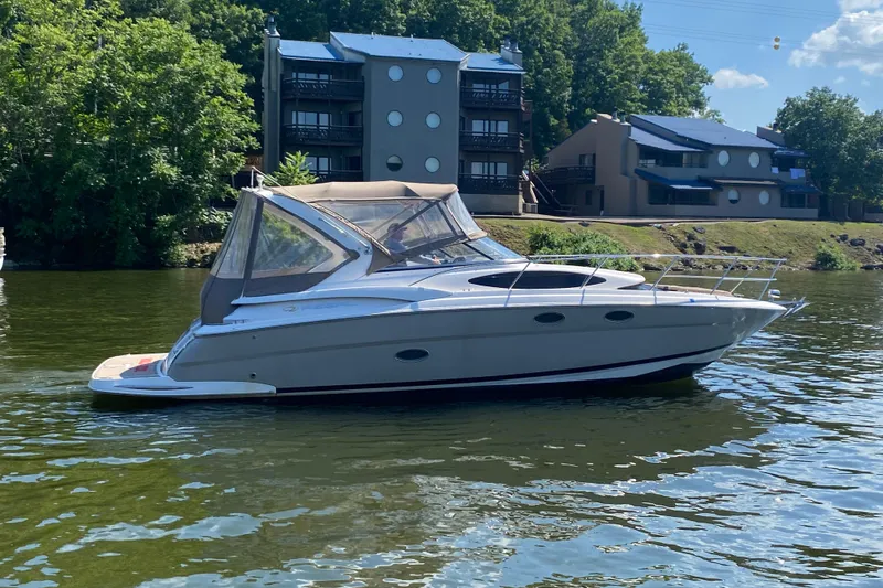 Slide: The Image of 2008 Regal 3360 Window Express boat on a calm river near modern buildings. - 1
