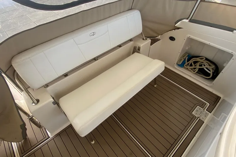 Slide: The Image of 2008 Regal 3360 Window Express boat interior with white seating and storage compartment. - 8