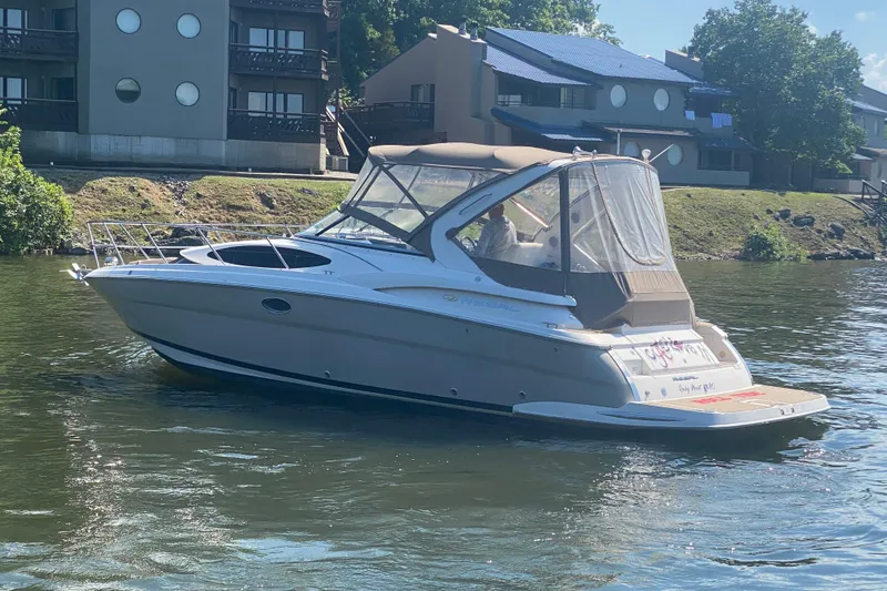 Slide: The Image of 2008 Regal 3360 Window Express boat on a calm river near residential buildings. - 5