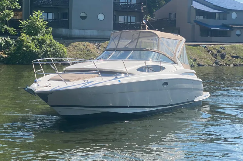 Slide: The Image of 2008 Regal 3360 Window Express boat on a calm river near residential buildings. - 7