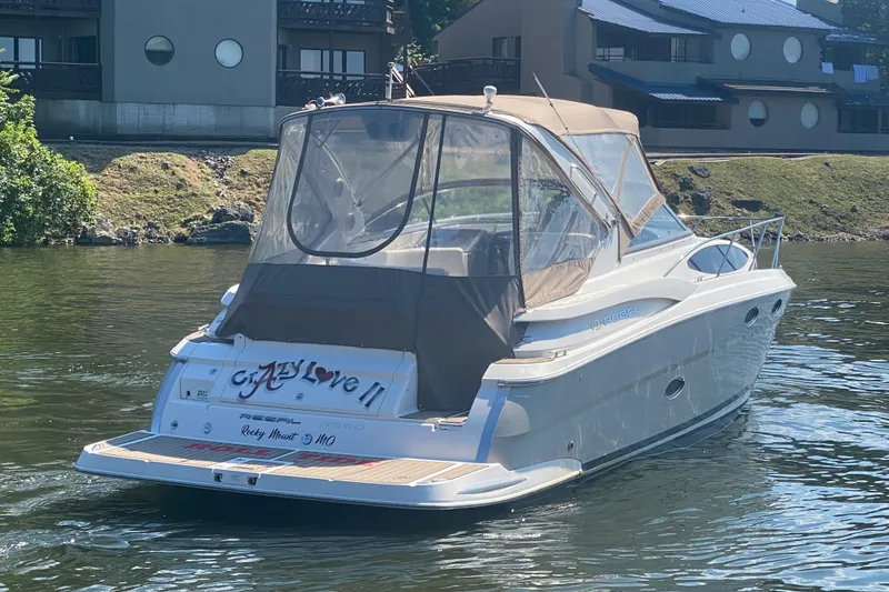 Slide: The Image of 2008 Regal 3360 Window Express boat on water near residential buildings. - 4