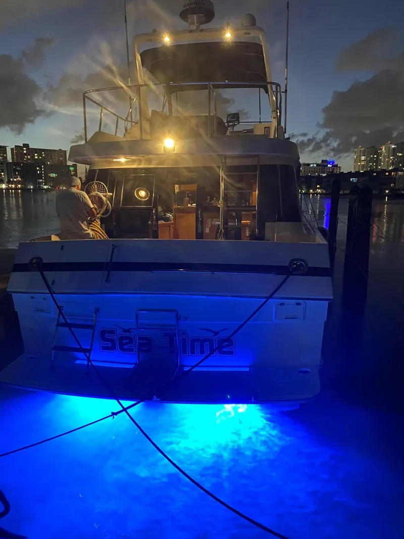 Slide: The Image of 1993 McKinna 48 Pilothouse yacht with blue underwater lights at night. - 10