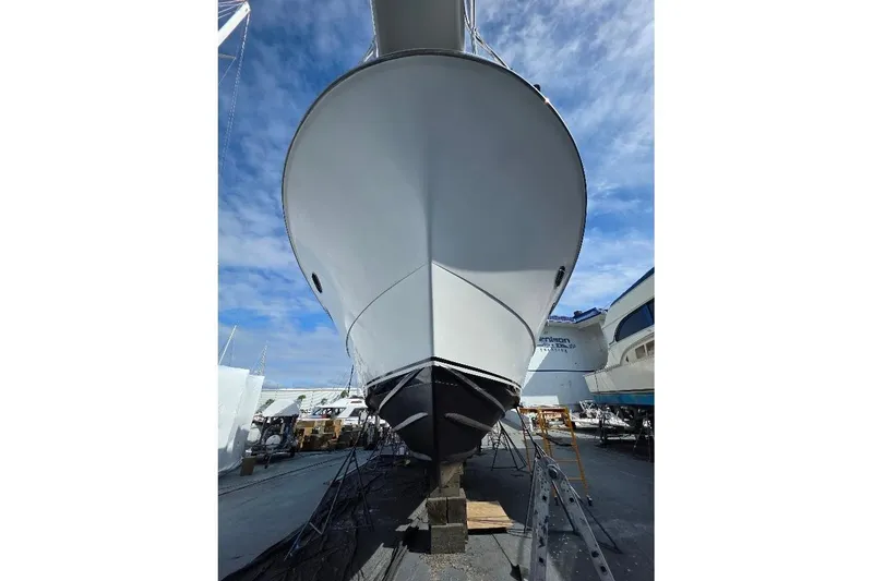 Slide: The Image of 1993 McKinna 48 Pilothouse yacht on dry dock under a clear blue sky. - 102