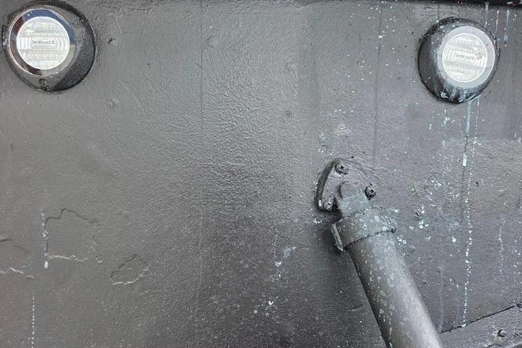 Slide: The Image of Black hull of 1993 McKinna 48 Pilothouse with circular fixtures and pipe detail. - 109