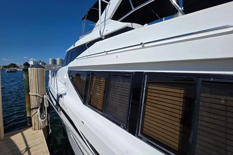 Slide: The Image of 1993 McKinna 48 Pilothouse yacht docked, showcasing sleek design and large windows. - 11