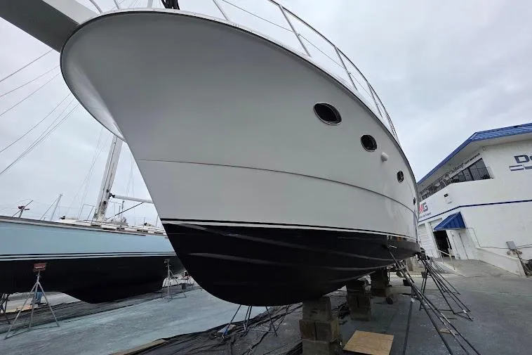 Slide: The Image of 1993 McKinna 48 Pilothouse yacht on dry dock, showcasing sleek hull design. - 112