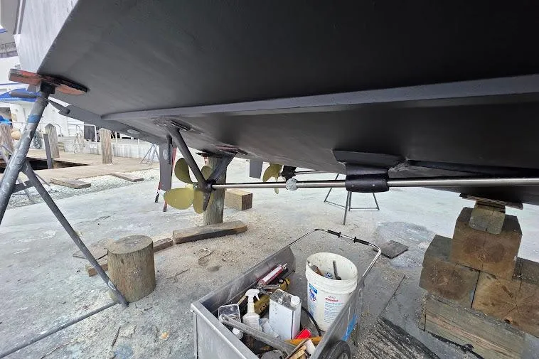 Slide: The Image of Underneath view of a 1993 McKinna 48 Pilothouse boat with visible propeller and maintenance tools. - 117