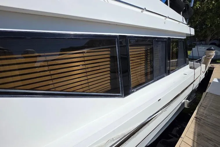 Slide: The Image of 1993 McKinna 48 Pilothouse yacht docked, featuring sleek windows and a white exterior. - 13