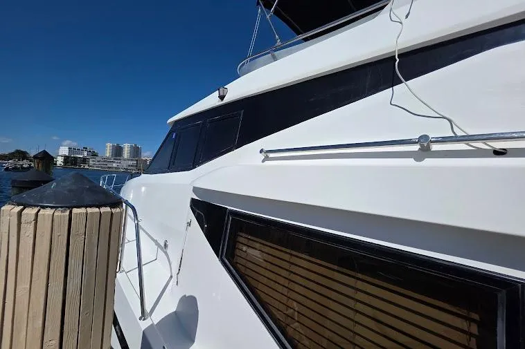 Slide: The Image of 1993 McKinna 48 Pilothouse yacht docked, showcasing sleek white exterior and modern design. - 14