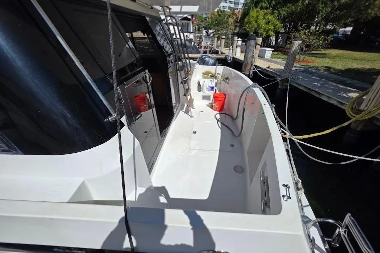 Slide: The Image of 1993 McKinna 48 Pilothouse yacht docked, featuring spacious deck and modern amenities. - 15