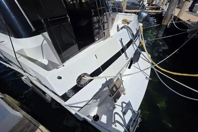 Slide: The Image of 1993 McKinna 48 Pilothouse yacht docked, showing rear deck and mooring ropes. - 16