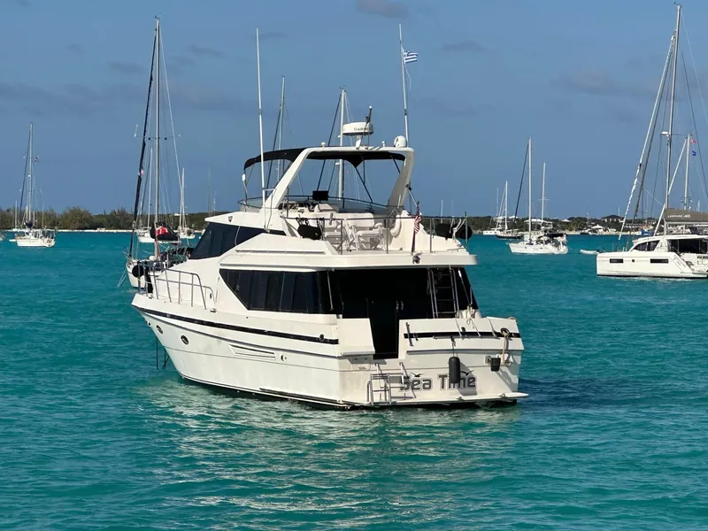 Slide: The Image of 1993 McKinna 48 Pilothouse yacht on turquoise water, surrounded by sailboats. - 2