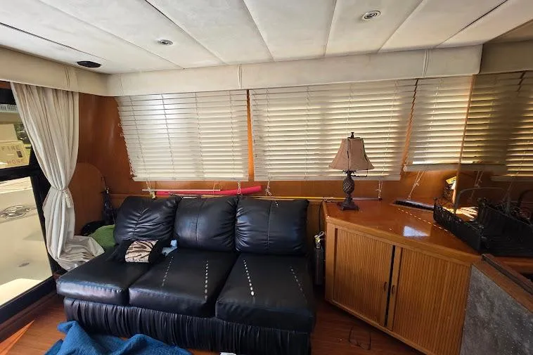 Slide: The Image of Interior of 1993 McKinna 48 Pilothouse with black leather sofa and wooden cabinetry. - 21